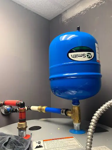 A blue tank sitting on top of a water heater.