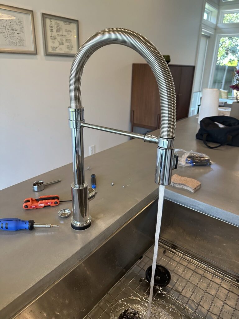 Chrome pull-down faucet fitted to a stainless steel sink