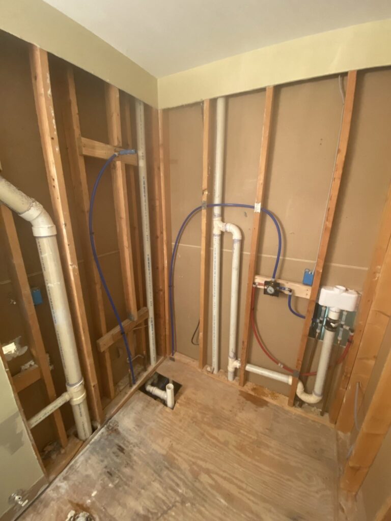 New water supply pipes run through an open stud wall during a whole-home repipe