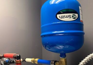 A blue tank sitting on top of a water heater.